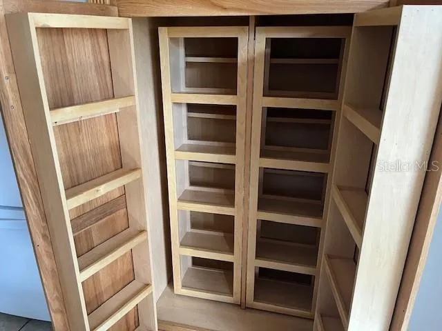 a view of walk in closet with empty racks