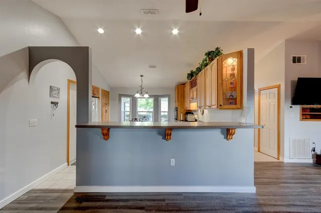a view of kitchen with stainless steel appliances granite countertop cabinets and wooden floor