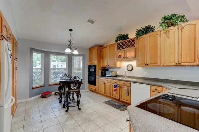 a kitchen with stainless steel appliances a stove a sink dishwasher and white cabinets with wooden floor