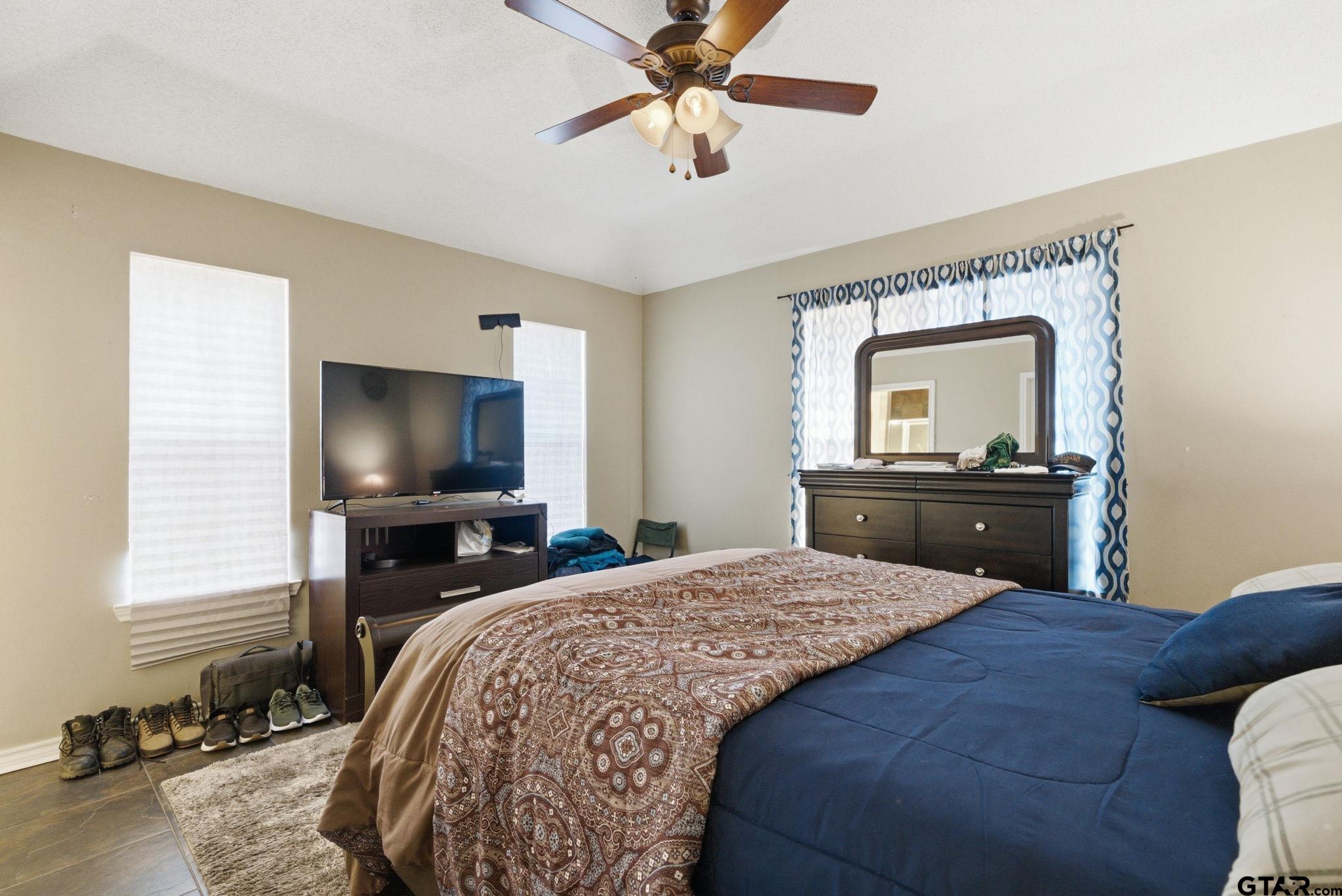 2301 McDonald Road Tyler, TX 75701 - Photo 11 of 26 a bedroom with a bed and a flat screen tv