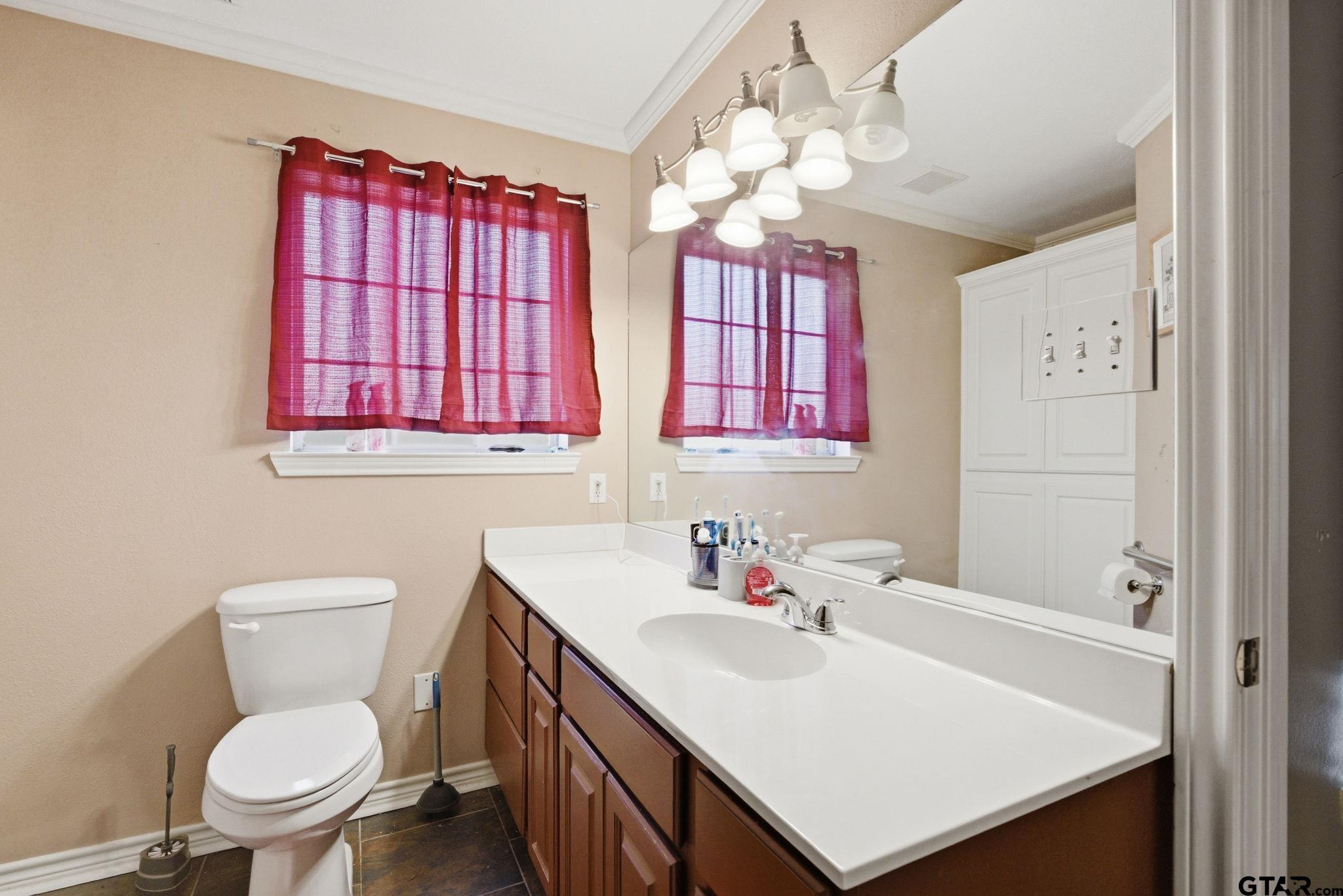 2301 McDonald Road Tyler, TX 75701 - Photo 14 of 26 a bathroom with a sink a toilet and a mirror