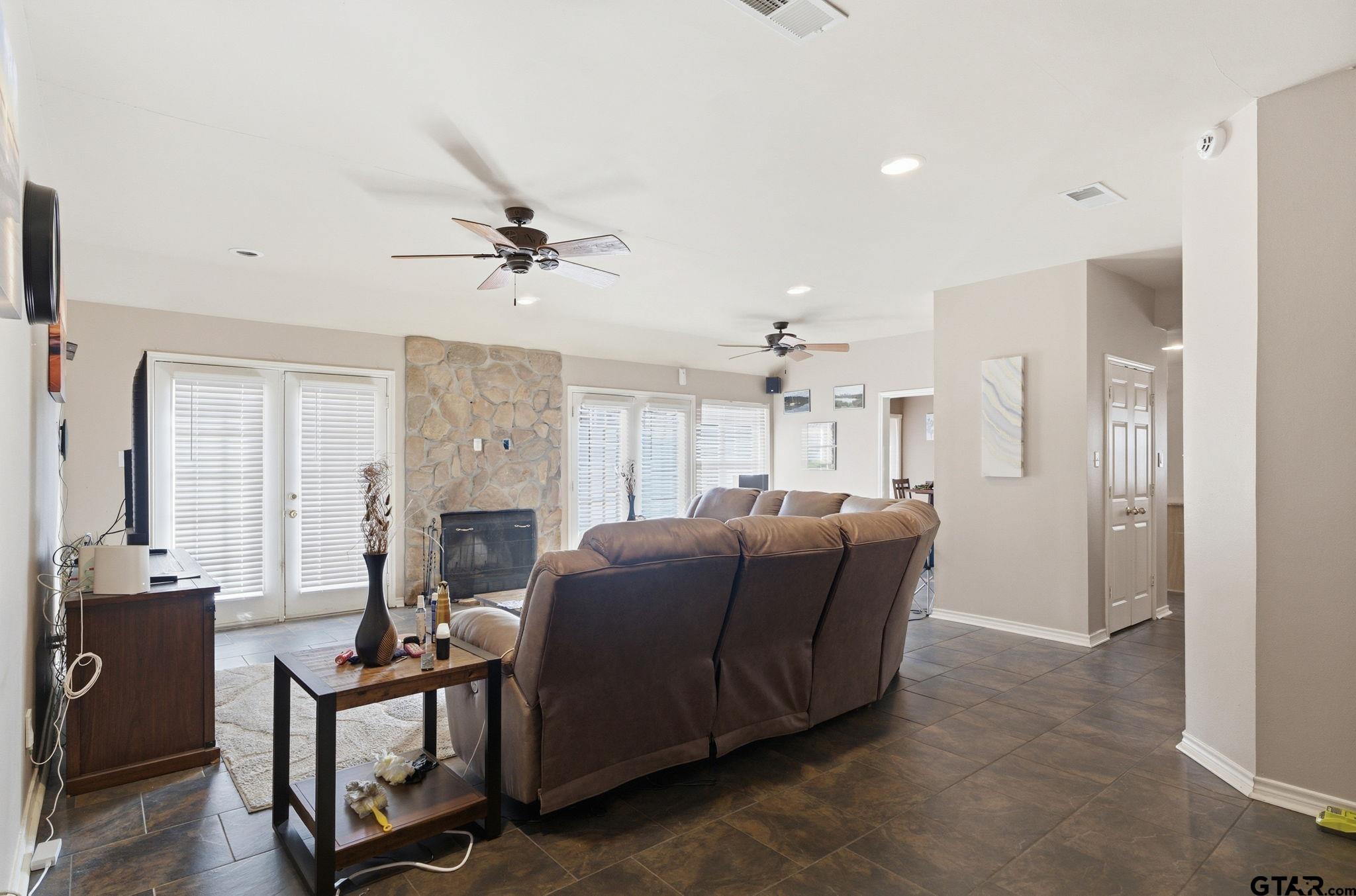 2301 McDonald Road Tyler, TX 75701 - Photo 2 of 26 a living room with furniture a fireplace and a ceiling fan