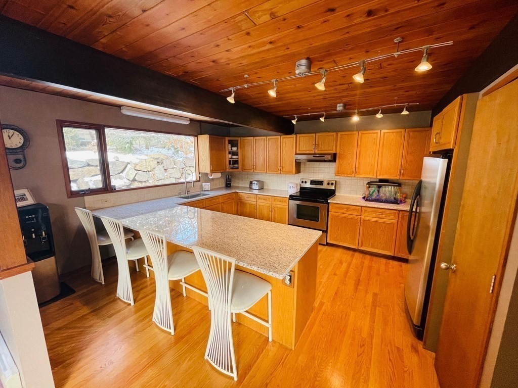 5 Clipper Way Beverly, MA 01915 - Photo 12 of 42 a kitchen with stainless steel appliances granite countertop a table chairs and a refrigerator