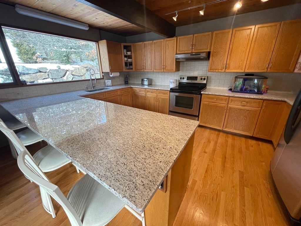5 Clipper Way Beverly, MA 01915 - Photo 15 of 42 a kitchen with granite countertop wooden cabinets and a granite counter tops