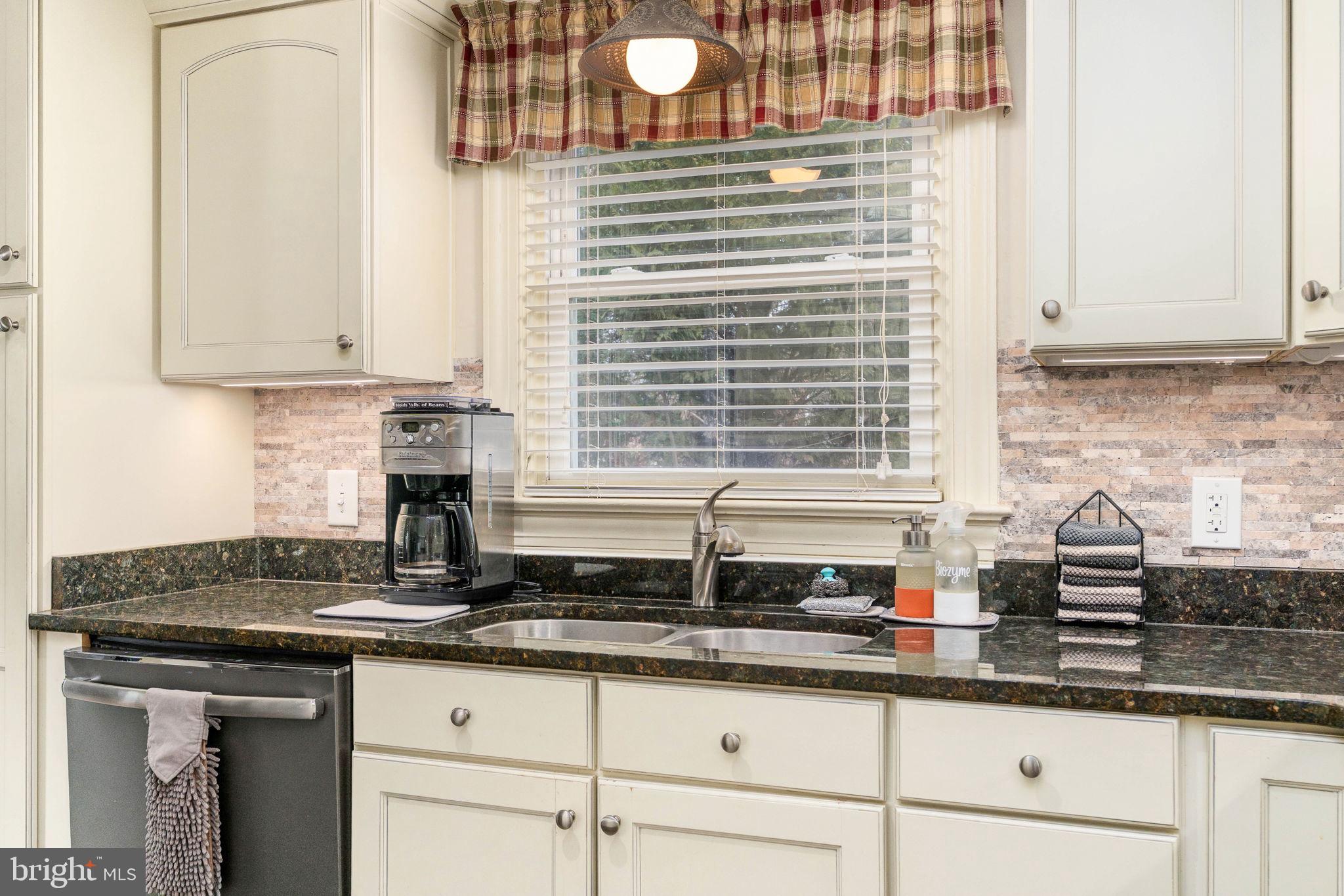 511 Ferry Road Fredericksburg, VA 22405 - Photo 18 of 55 a kitchen with granite countertop a sink a window and cabinets