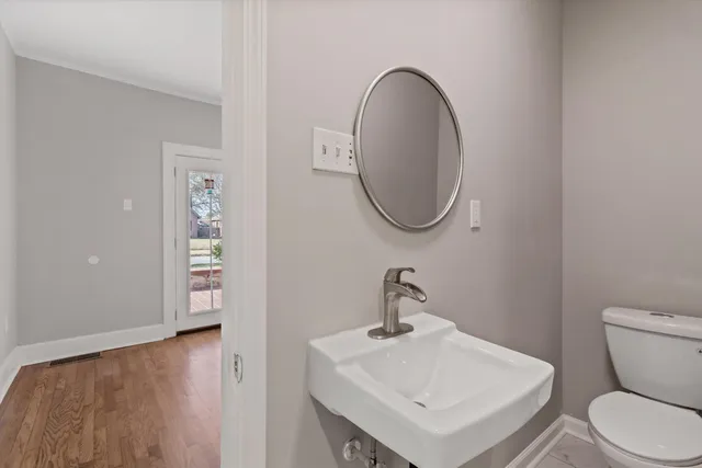 a bathroom with a toilet a sink and a mirror