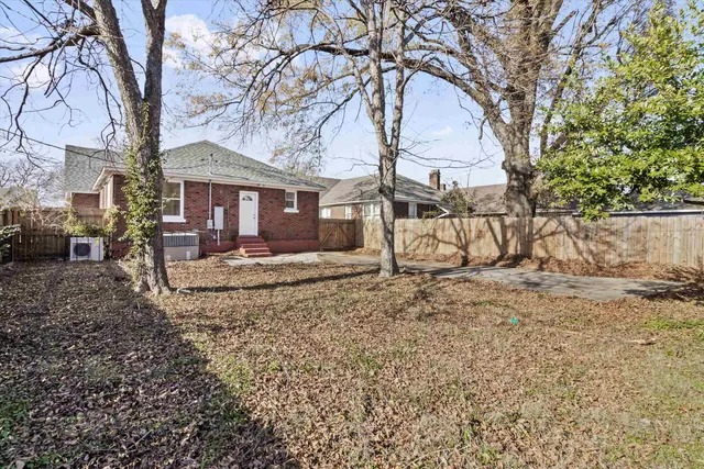 a view of a house with a yard covered in the forest