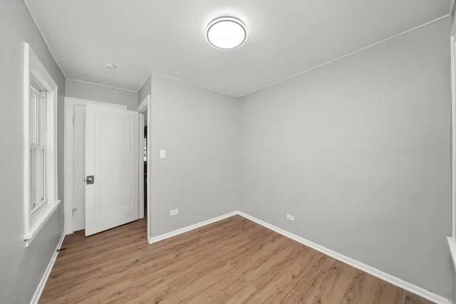 a view of a room with wooden floor and window