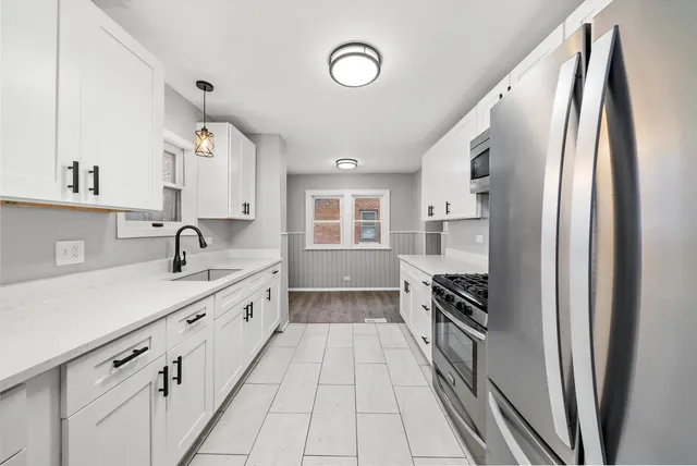 a kitchen with granite countertop a refrigerator and a sink
