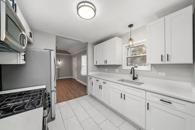 a kitchen with granite countertop white cabinets and white appliances