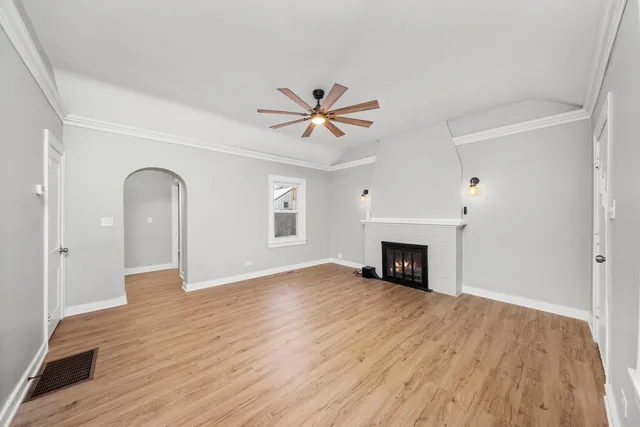 a view of empty room with a fireplace and wooden floor