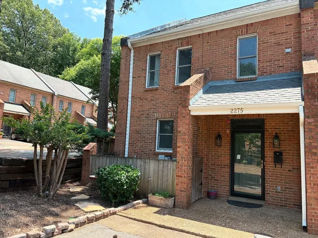 a view of brick house with potted plants