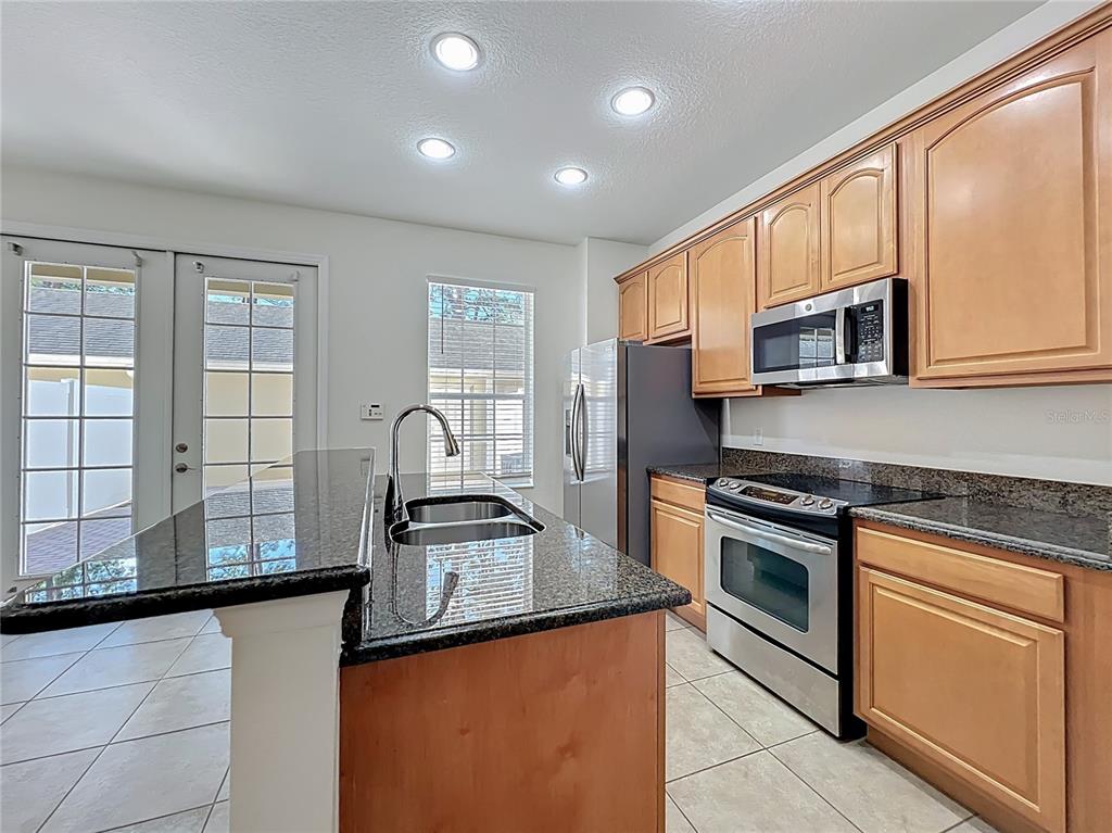 12930 Vennetta Way Windermere, FL 34786 - Photo 6 of 38 a kitchen with stainless steel appliances granite countertop a stove a sink and a microwave