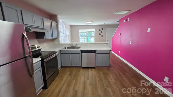 a kitchen with a sink a stove top oven a refrigerator and cabinets