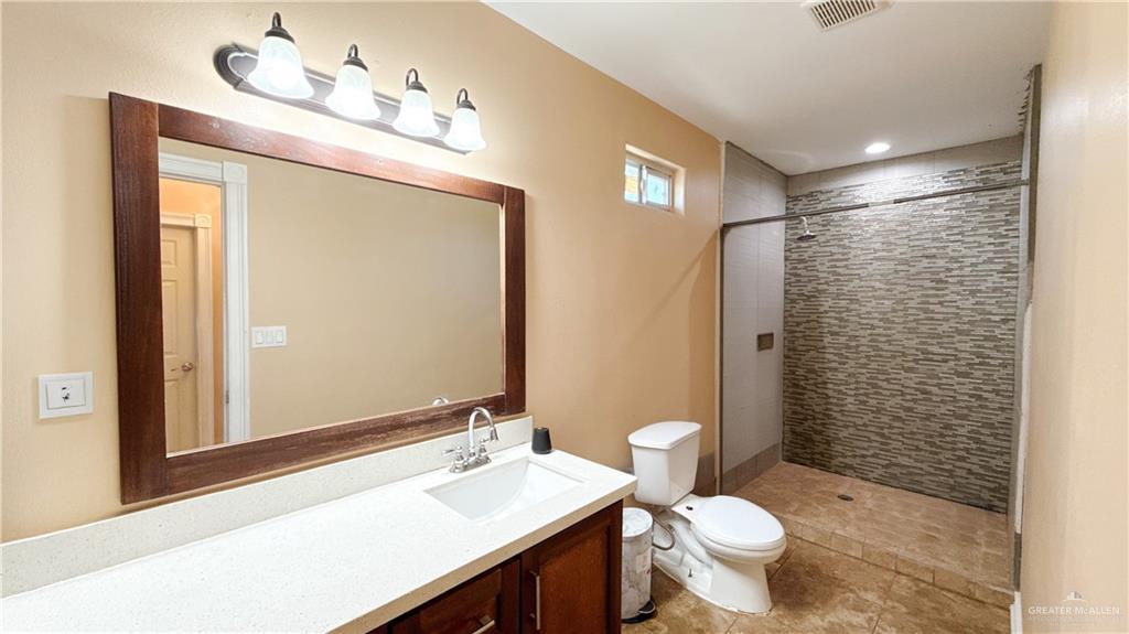1301 Minnesota Road Pharr, TX 78577 - Photo 23 of 28 a bathroom with a sink a toilet and shower curtain