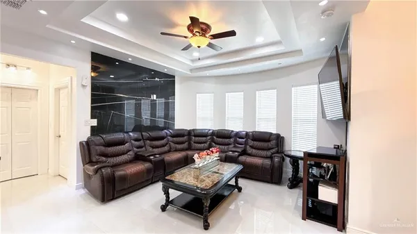 a living room with furniture ceiling fan and a rug