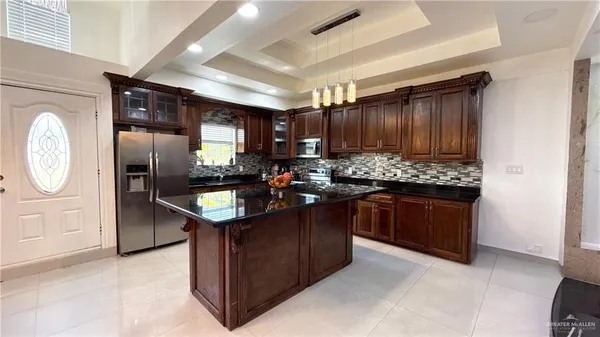 a kitchen with granite countertop stainless steel appliances a stove refrigerator and cabinets