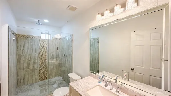 a bathroom with a double vanity sink toilet and shower