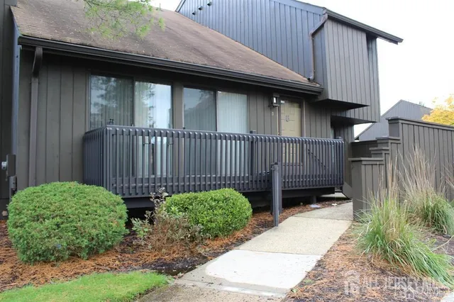 a view of a backyard with plants and wooden fence