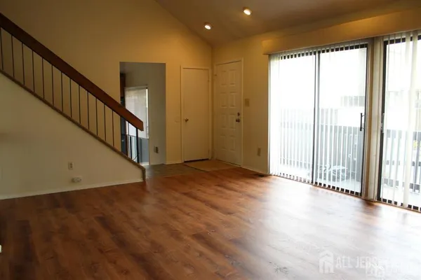 a view of a room with wooden floor and windows