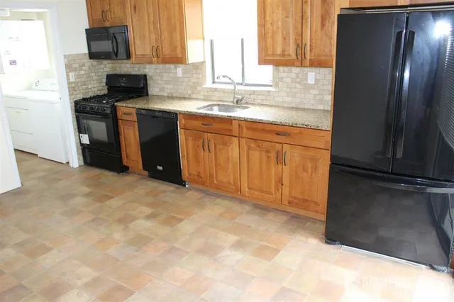 a kitchen with stainless steel appliances granite countertop a refrigerator and a sink