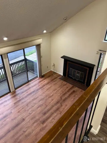 a view of a hallway to a room with wooden floor