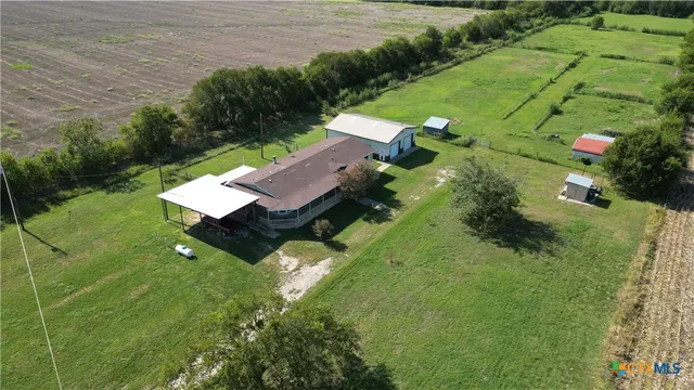 an aerial view of a house with pool yard and outdoor seating