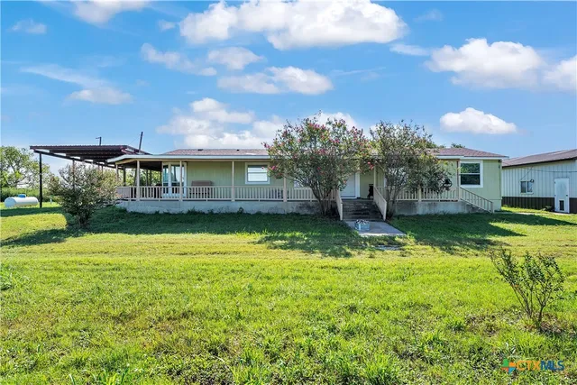 a view of a house with a backyard