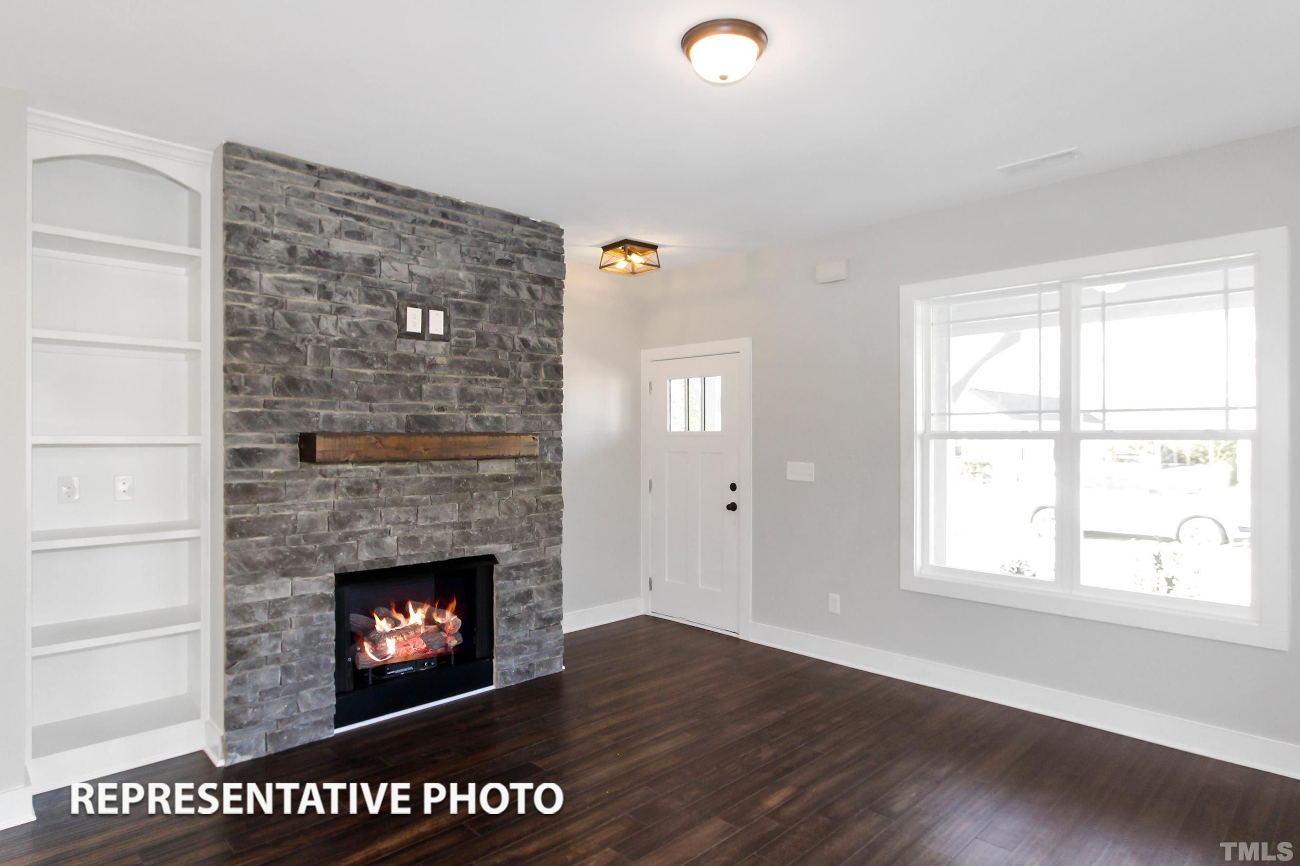 57 Longbow Drive Middlesex, NC 27557 - Photo 3 of 6 a view of an empty room with wooden floor fireplace and a window