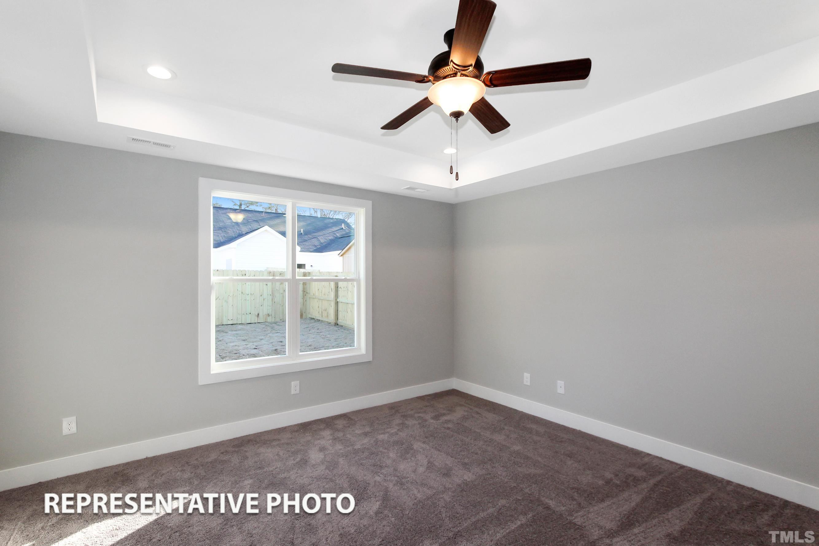 57 Longbow Drive Middlesex, NC 27557 - Photo 4 of 6 an empty room with a ceiling fan and windows