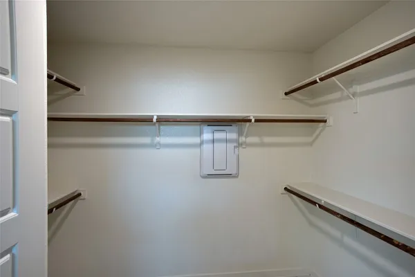 a view of an empty room with a window and closet area