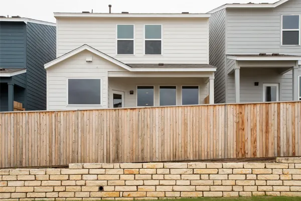 a view of a house with a wooden fence