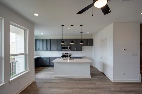 a kitchen with kitchen island a sink stainless steel appliances and window