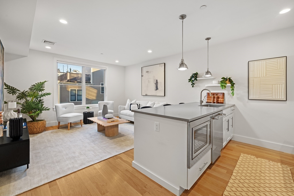 150 West Broadway, Unit 313A Boston, MA 02127 - Photo 1 of 10 a kitchen with a stove and a wooden floor