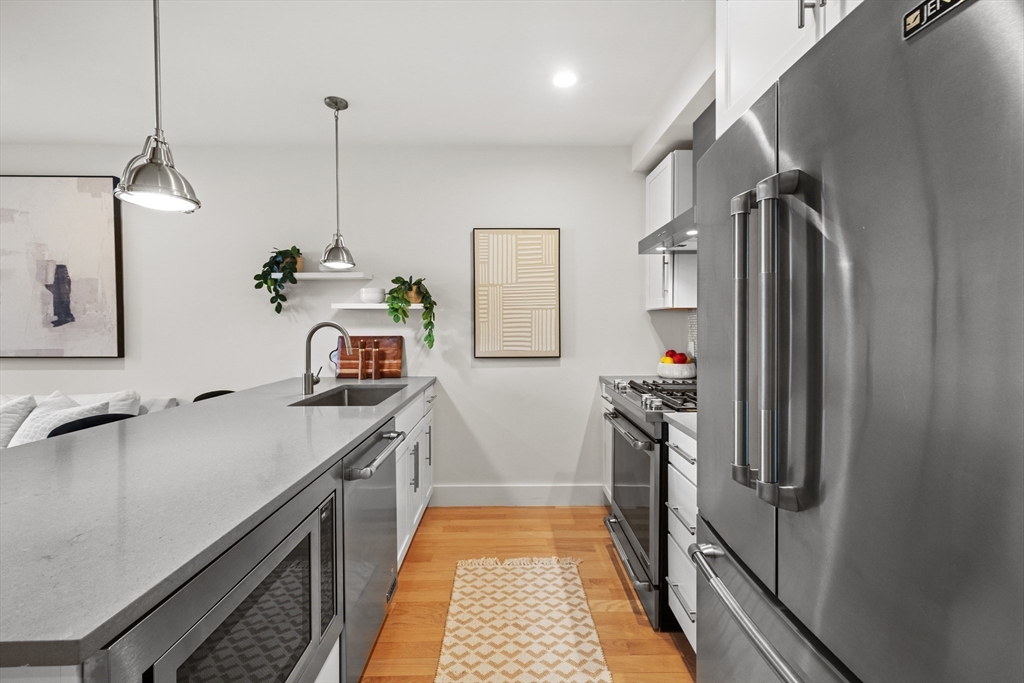 150 West Broadway, Unit 313A Boston, MA 02127 - Photo 3 of 10 a kitchen with stainless steel appliances a sink stove and refrigerator