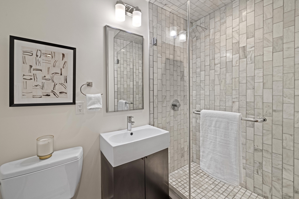150 West Broadway, Unit 313A Boston, MA 02127 - Photo 7 of 10 a bathroom with a toilet sink and shower