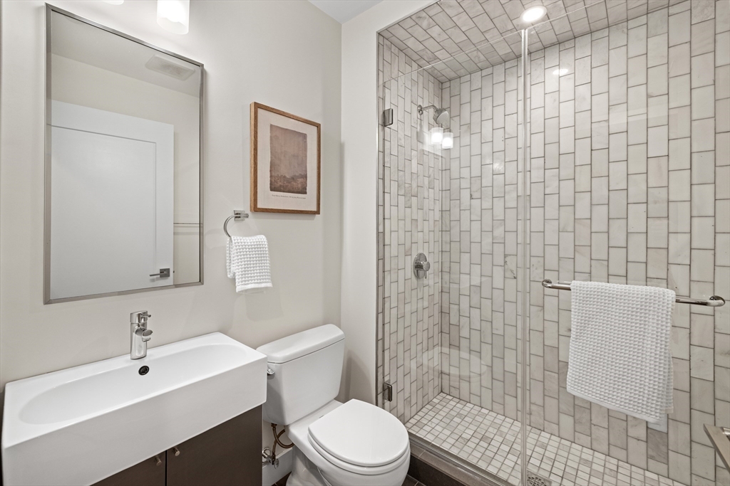 150 West Broadway, Unit 313A Boston, MA 02127 - Photo 9 of 10 a bathroom with a sink a toilet and shower