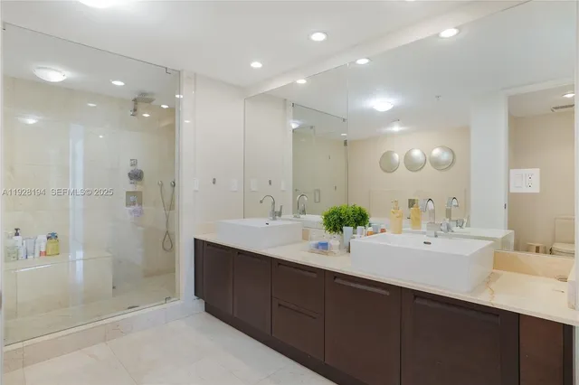 a bathroom with a double vanity sink mirror and shower