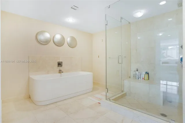 a bathroom with a tub and a glass shower door