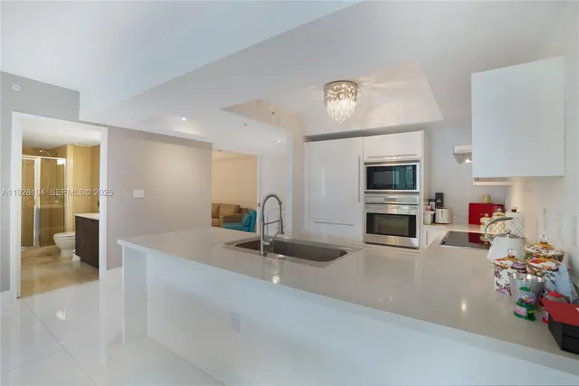 a kitchen with sink white cabinets and appliances