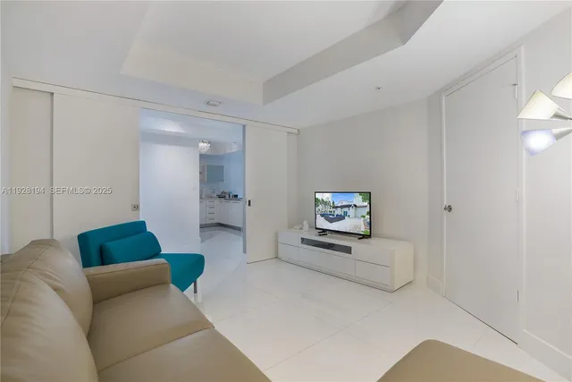 a living room with furniture and a view of bathroom