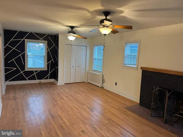 a view of a livingroom with wooden floor and a ceiling fan