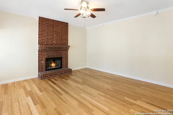 a view of empty room with wooden floor and fireplace