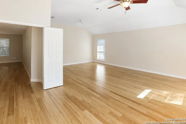 a view of empty room with wooden floor