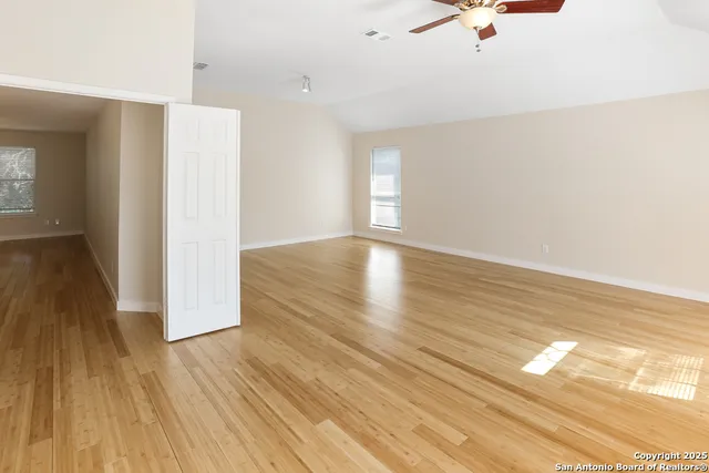 a view of empty room with wooden floor