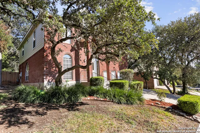 a front view of a house with a tree