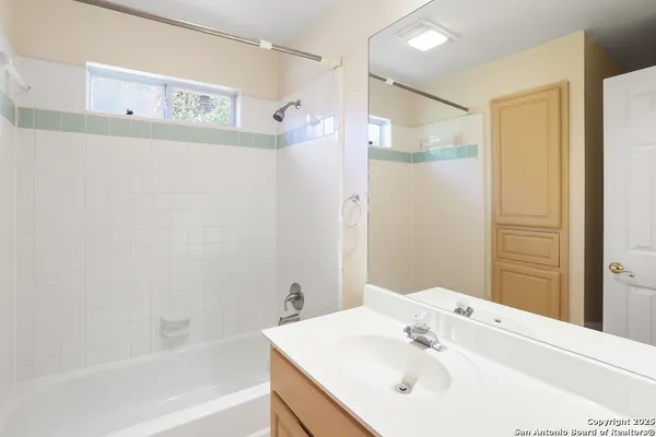a bathroom with a bathtub shower sink and a mirror