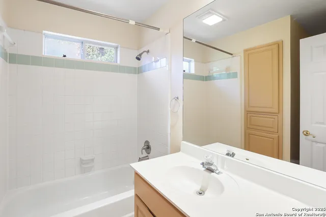 a bathroom with a bathtub shower sink and a mirror