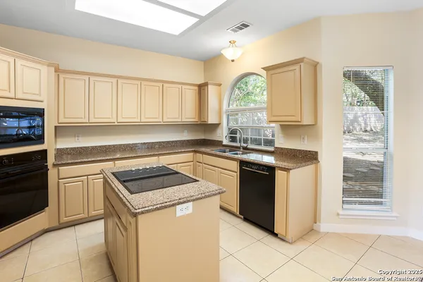 a kitchen with granite countertop a sink stainless steel appliances and cabinets