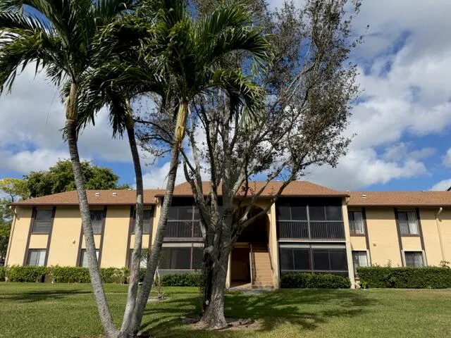 a front view of a house with a yard and potted plants